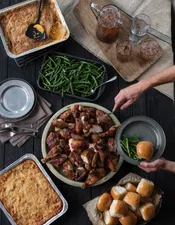 Wood-fired rotisserie chicken with sides of Green Beans, Twice Baked Taters, Peach Cobbler and rolls. Iced tea to drink.