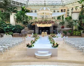 Wedding at Emerald Bay Plaza – An elegant indoor atrium venue surrounded by lush greenery, cascading water features, and natural light beneath soaring glass ceilings.