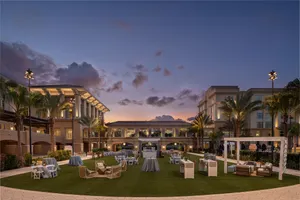 Mangrove Lawn Event Setup – A scenic outdoor venue set with tables and chairs, perfect for gatherings amid lush landscaping and open-air charm.