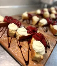 Our pistachio and olive oil cake is topped with house-made vanilla whipped cream and roasted strawberry jam