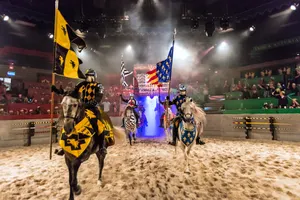 knights on horseback charge out of tunnel into arena