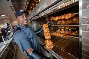 Operating Partner Phil showcasing rotisserie chicken fresh from the fire.