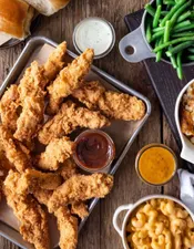 Family Chicken Tenders with Ranch, BBQ, and Honey Blaze sauces and sides of green beans, Mac n cheese and rolls.