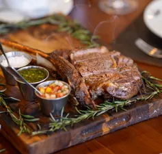 32 oz Fire-roasted Tomahawk steak served with 3 sides