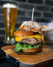 Lettuce, tomato, cheddar cheese, in a soft Bavarian pretzel bun, topped with a crispy house made beer battered onion ring.
