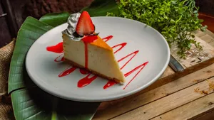 Cheesecake with homemade vanilla bean whipped cream & mixed berry coulis