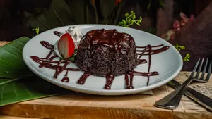A rich chocolate ganache filled chocolate torte, served hot with fresh vanilla bean whipped cream.