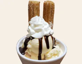 Churro Sundae Vanilla Ice Cream, 2 pieces of Churro, Chocolate drizzle and Whip Cream.