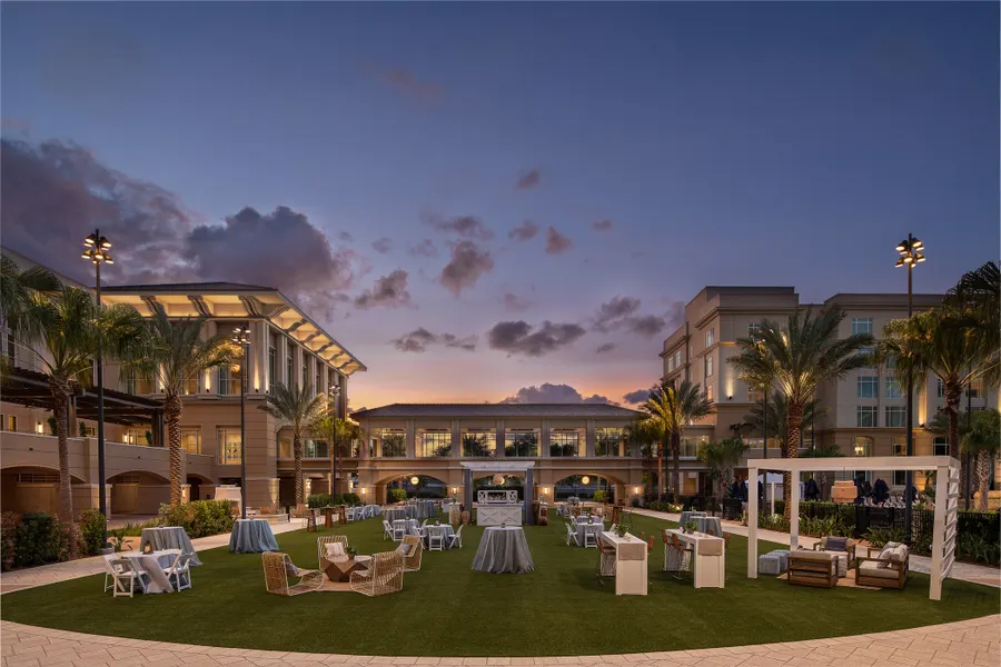 Mangrove Lawn Event Setup – A scenic outdoor venue set with tables and chairs, perfect for gatherings amid lush landscaping and open-air charm.