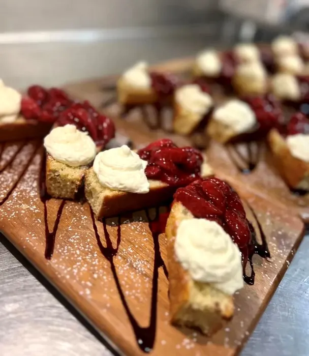Our pistachio and olive oil cake is topped with house-made vanilla whipped cream and roasted strawberry jam