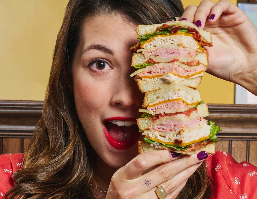 Guest-favorite Metro Club Sandwich - Ham, turkey, bacon, Swiss, Cheddar, lettuce, tomato and mayo on three slices of white toast