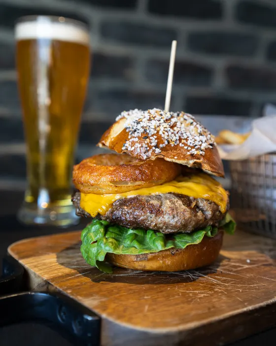Lettuce, tomato, cheddar cheese, in a soft Bavarian pretzel bun, topped with a crispy house made beer battered onion ring.