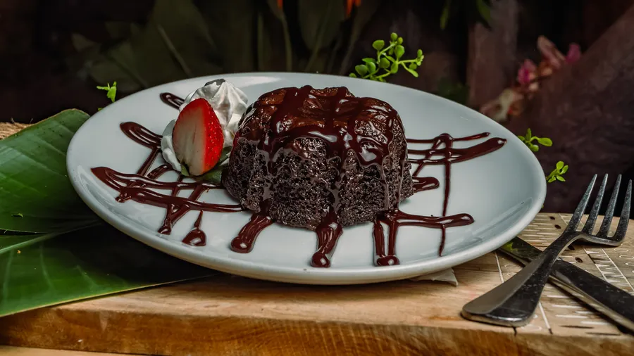 A rich chocolate ganache filled chocolate torte, served hot with fresh vanilla bean whipped cream.