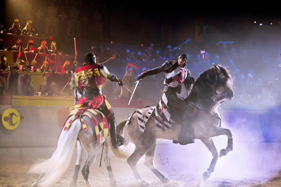 two knights fight with swords on horseback