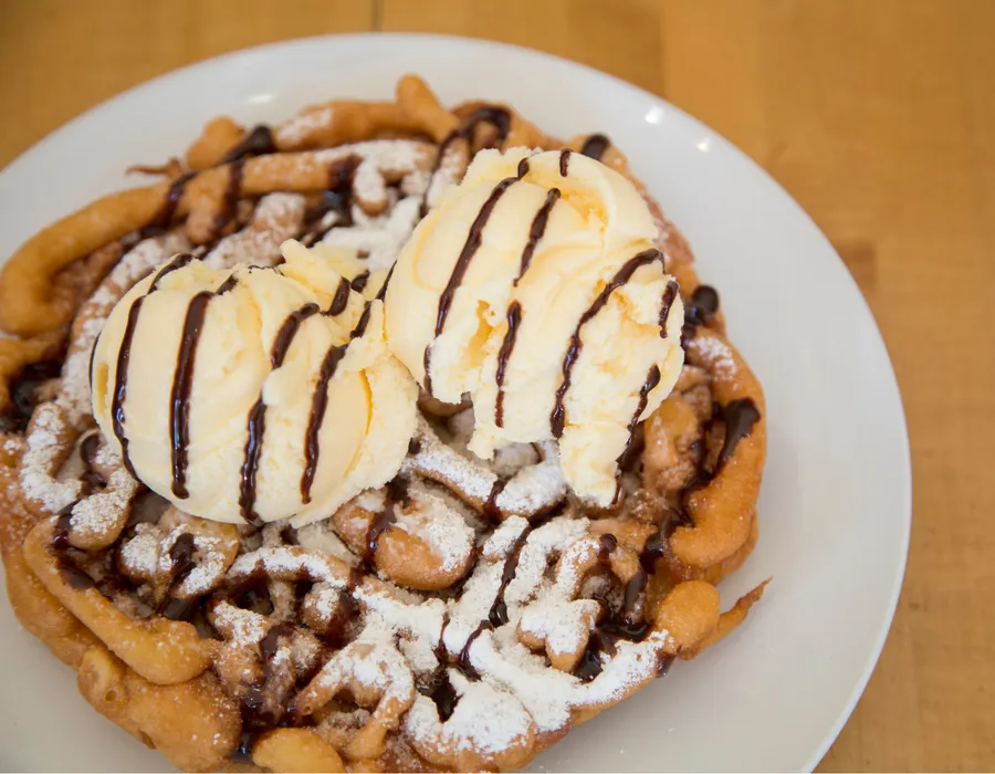 Sundae Funnel Cake with Vanilla Ice Cream and Hershey Chocolate drizzle.