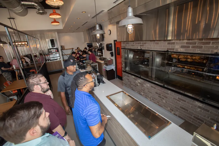 Guests watching the rotisserie chicken on the fire